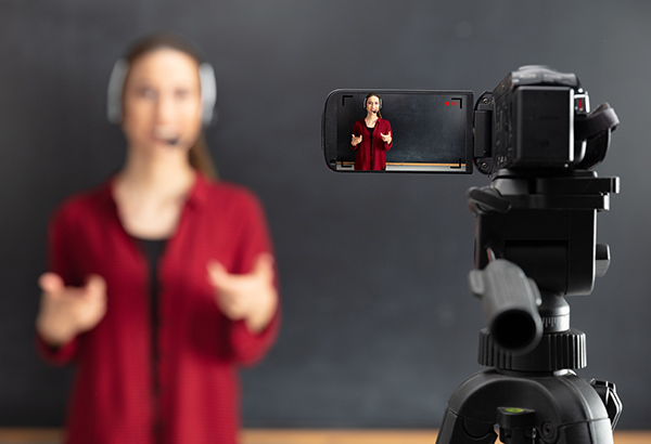Video camera records person talking in front of chalkboard
