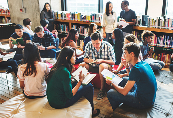 group-of-students-actively-talking-in-circle-with-books